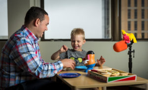 Image of child and lab member with play materials